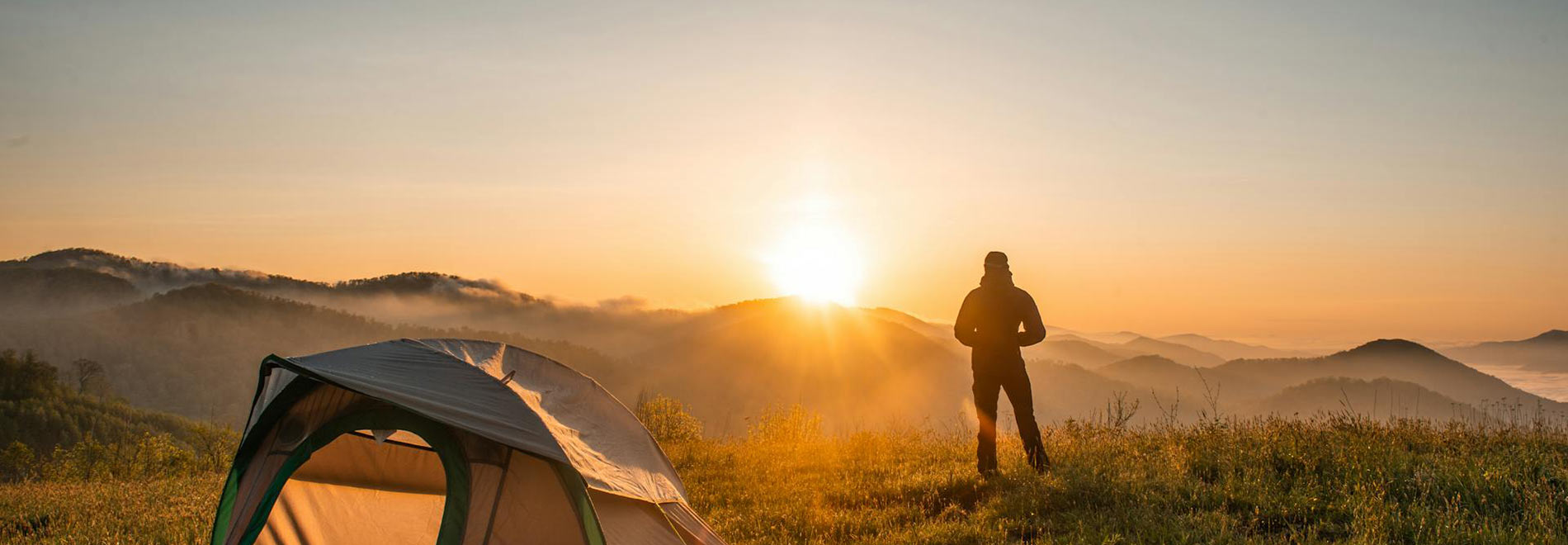 A man camping and hiking in rural hills