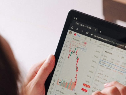 A person using a smart tablet to view investments