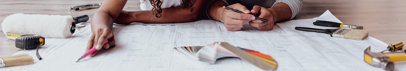 Two people looking at house remodeling blueprints