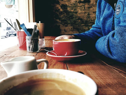 A man at a restaurant drinking coffee