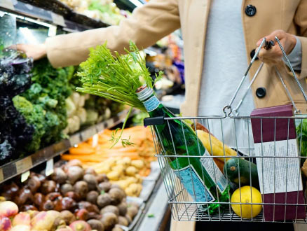 A lady shopping for produce in a grocery store