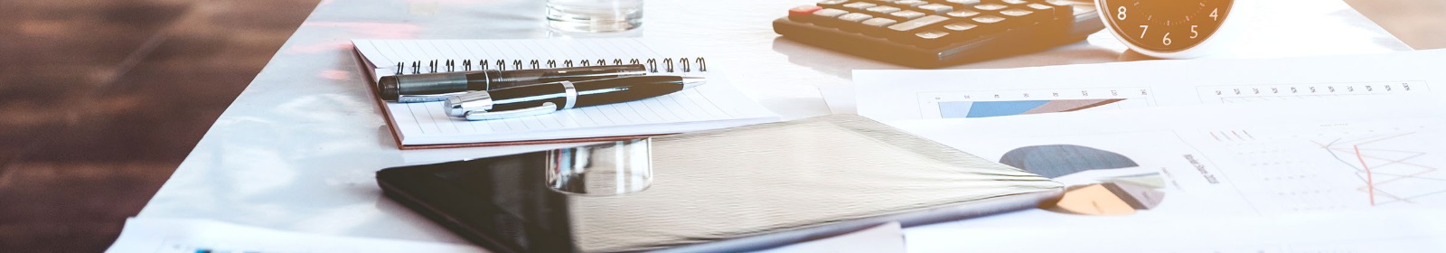 documents, notepad, writing pen and a calculator on a desk